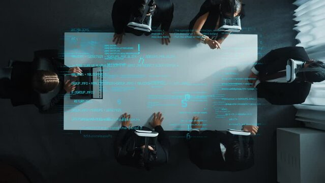 Top down aerial view of professional business team wear vr headset while stands around coding engineering prompt holographic and using hand gestures to manipulate the data from the manager laptop.