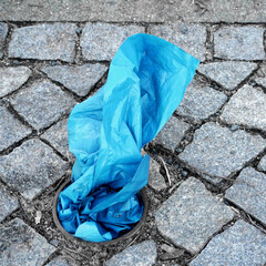 blue plastic sheet plugged into a circular hole in the pavement