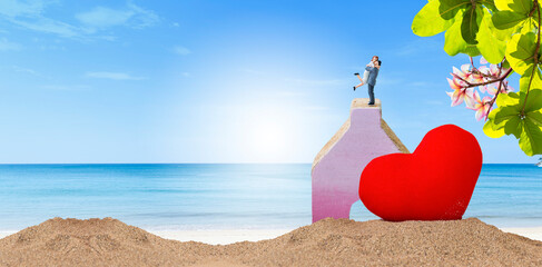 Miniature couple with red heart on tropical beach, just marriage, love and romance concept, valentine card background idea