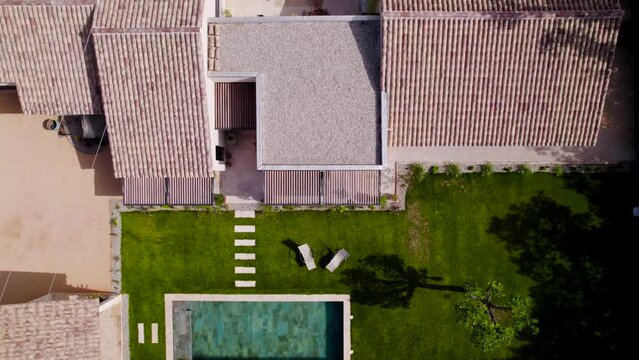 Top shot of a Provencal house in the south of France with its Bali stone swimming pool and its small green garden, the tiles are from the south