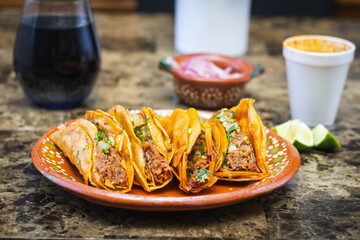four birria tacos in a clay plate. traditional mexican food