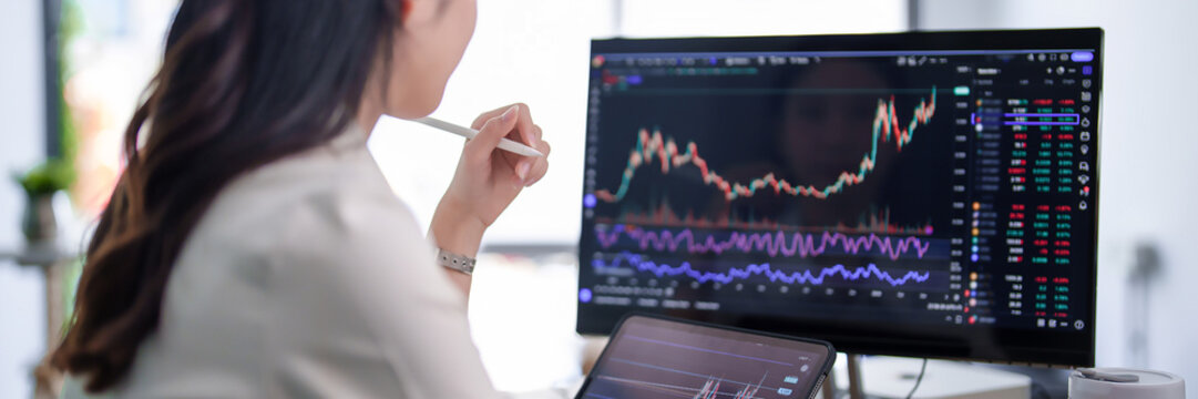 Investor businesswoman checking business stock data on computer and tablet while working about stock and marketing of new startup to analysis trade with investment of business project in office