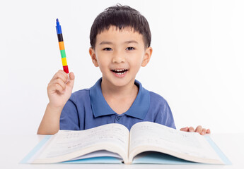 Smiling asian child schoolboy studying and drawing at home