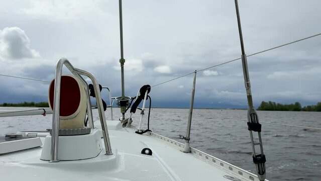 Forward view of a sailboat deck, dorade and pulpit on a Frisian lake in The Netherlands with a dark, ominous, storm sky