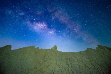 Blue starry sky and Milky Way at night. The texture of the hills. Caoshan Moon World is a chalky...