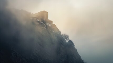 view from a mysterious medieval castle on a rocky mountain cliff shrouded in cold, dark morning mist. Creates a scary atmosphere