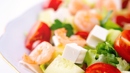 Salad in a Greek shrimp salad. A close-up salad of fresh vegetables, a plate of fresh salad with vegetables and herbs. The concept of a delicious and healthy dish. Greek salad with juicy tomatoes