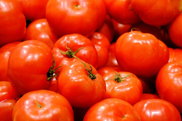 Close-up of beautiful red tomatoes in a tray in a store.