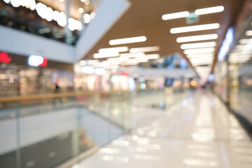 Blurred beautiful interior in modern shopping mall with glass roof.