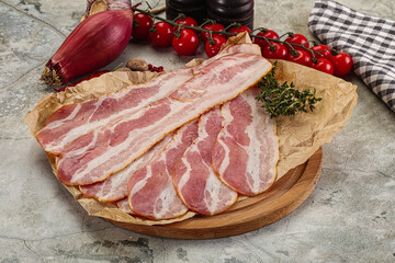 Sliced pork bacon over board