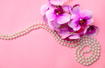 Pearl necklace and Purple orchid on pink background