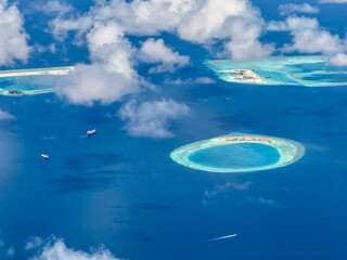 aerial landscape view of the almost round Kuda Giri Reef in Maldives with sand beach, surrounded by...