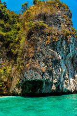Large rock cliffs covered with green trees face directly to the vast Andaman Sea. The view of rock...