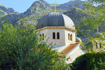 Fototapeta na wymiar The dome of the main Orthodox church of Kotor - the Church of St. Nicholas, against the backdrop of greenery and mountains (Montenegro)
