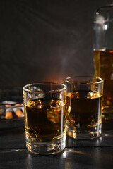 Alcohol addiction. Whiskey in glasses on black wooden table