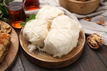 Eastern sweets. Tasty Iranian pashmak and tea on wooden table, closeup