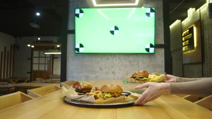 Close-up of fast food or snacks in a modern, stylish bar or restaurant against a green screen for your advertising. Small business, menu and holiday advertising concept.