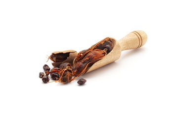 Front view of a wooden scoop filled with Fresh Organic Sweet Tamarind (Tamarindus indica) Frruit. Isolated on a white background. - obrazy, fototapety, plakaty