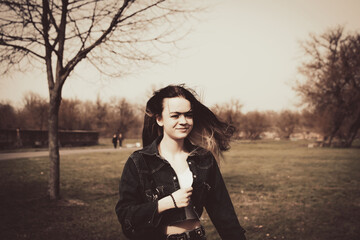 A young girl walks in the park near the old fortress - obrazy, fototapety, plakaty