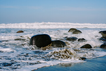 Morning tranquility captured in a serene coastal image, featuring small waves, rocky beach, and the calming aura of dawn