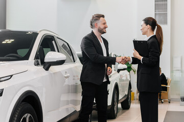 An interested buyer consults with a car dealership manager about the models and characteristics of...