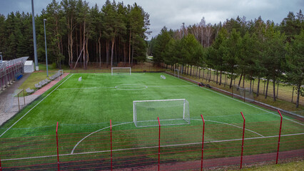 football field with green grass with goals and a soccer ball