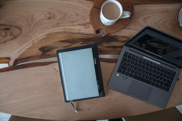 Wooden table with laptop and notepad for notes