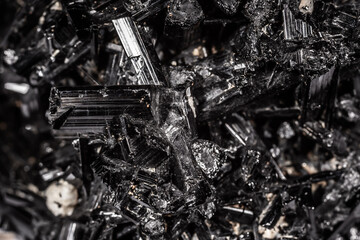 Tourmaline black crystals. Gems. Mineral crystals in the natural environment. Texture of precious and semiprecious stones. Seamless background with copy space colored shiny surface of precious stones.