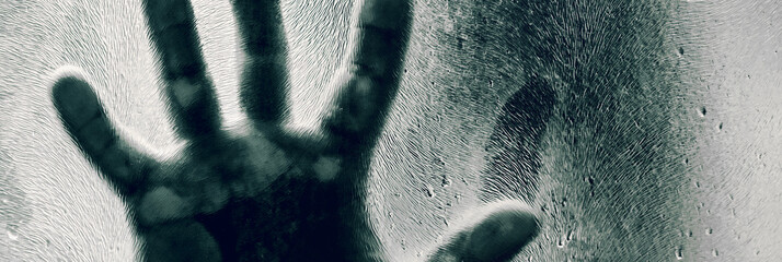 Mans figure with hands pressed against frosted glass. Shadow of a man behind the matte glass blurry...