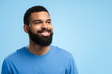African American man posing in studio over blue background with copy space. Advertisement concept