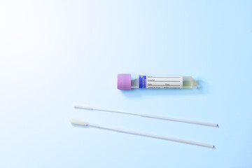 A syringe with a purple cap and a white label. The syringe is next to a plastic stick
