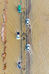 cars moving along a country road flooded from floods and floods, photographed from a drone and a helicopter