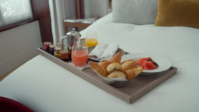 Breakfast Tray with Fresh Pastries and Juice on Bed