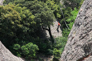 climber climbs to the top, rocks around Montserrat monastery, near Barcelona, Catalonia, Spain - obrazy, fototapety, plakaty