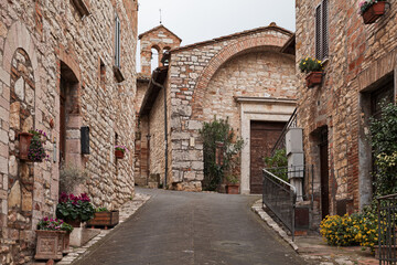 Corciano, Perugia, Umbria, Italy: narrow alley and the ancient Church of San Cristoforo, now home to a museum, in the old town of the picturesque village - 789108949