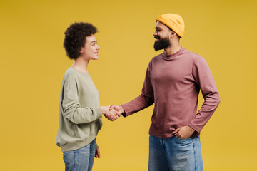 Obraz premium Happy African American couple holding hands folded handshake gesture, posing in studio