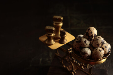 Fresh quail eggs on antique scales. The weights on the scales are made of brass. Rustic style on a...