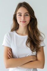 Portrait of a smiling young woman with crossed arms, wearing a white t-shirt, exuding confidence.