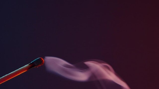 White smoke from an extinguished match on dark background
