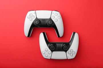 Wireless game controllers on red background, flat lay