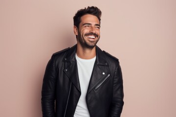 Fototapeta premium Portrait of a grinning man in his 30s sporting a classic leather jacket isolated in solid pastel color wall