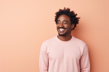 Portrait of a smiling afro-american man in his 30s sporting a long-sleeved thermal undershirt while standing against solid pastel color wall - obrazy, fototapety, plakaty