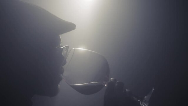 Sommeliers male with hat hold glass red wine tasting degustation card, Cinematic light scene with fog