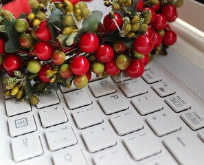 Decorative Garland With Plastic Berries And Branches On White Laptop Keyboard

