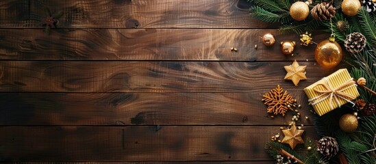 Top view of a wooden table decorated with a Christmas gift box, food ornaments, and a branch from a fir tree. There is space for text. - Powered by Adobe