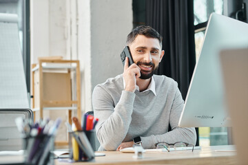 A man engrossed in a call while sitting at his desk in an office setting, part of a team focused on...