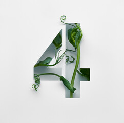 The number four is made from young pea shoots on a white background.