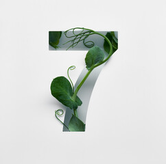 The number seven is made from young pea shoots on a white background.