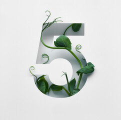 The number five is made from young pea shoots on a white background.