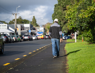 Man walking on a pedestrian footpath. Busy traffic on the road. Auckland. - 789140104